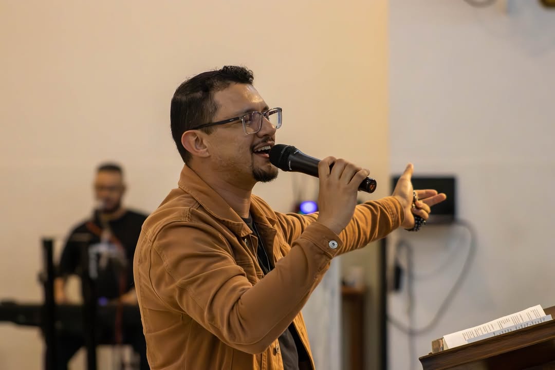 Leonardo Lima conduzindo uma palestra com microfone